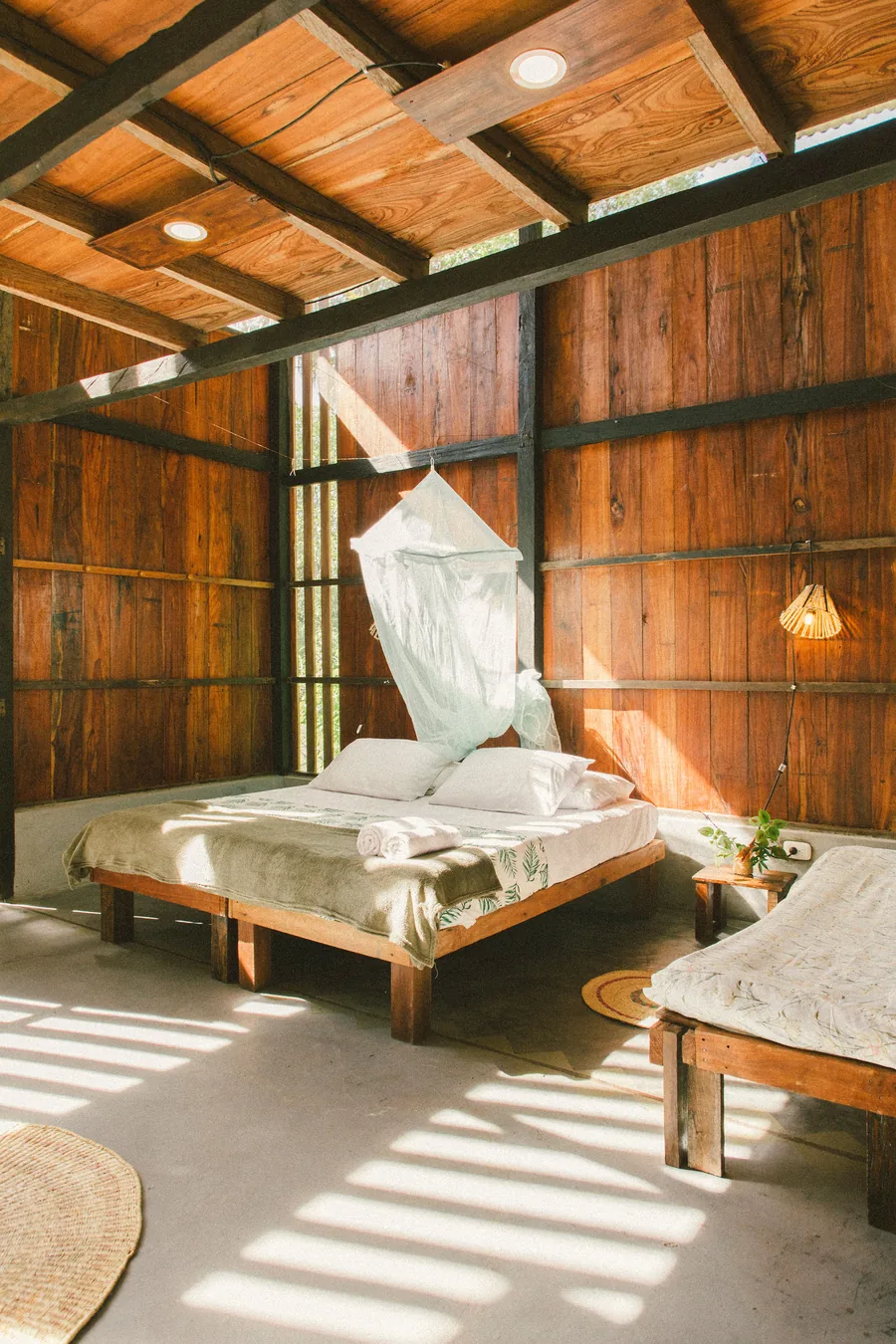 Cama con mosquitero dentro de la cabaña
