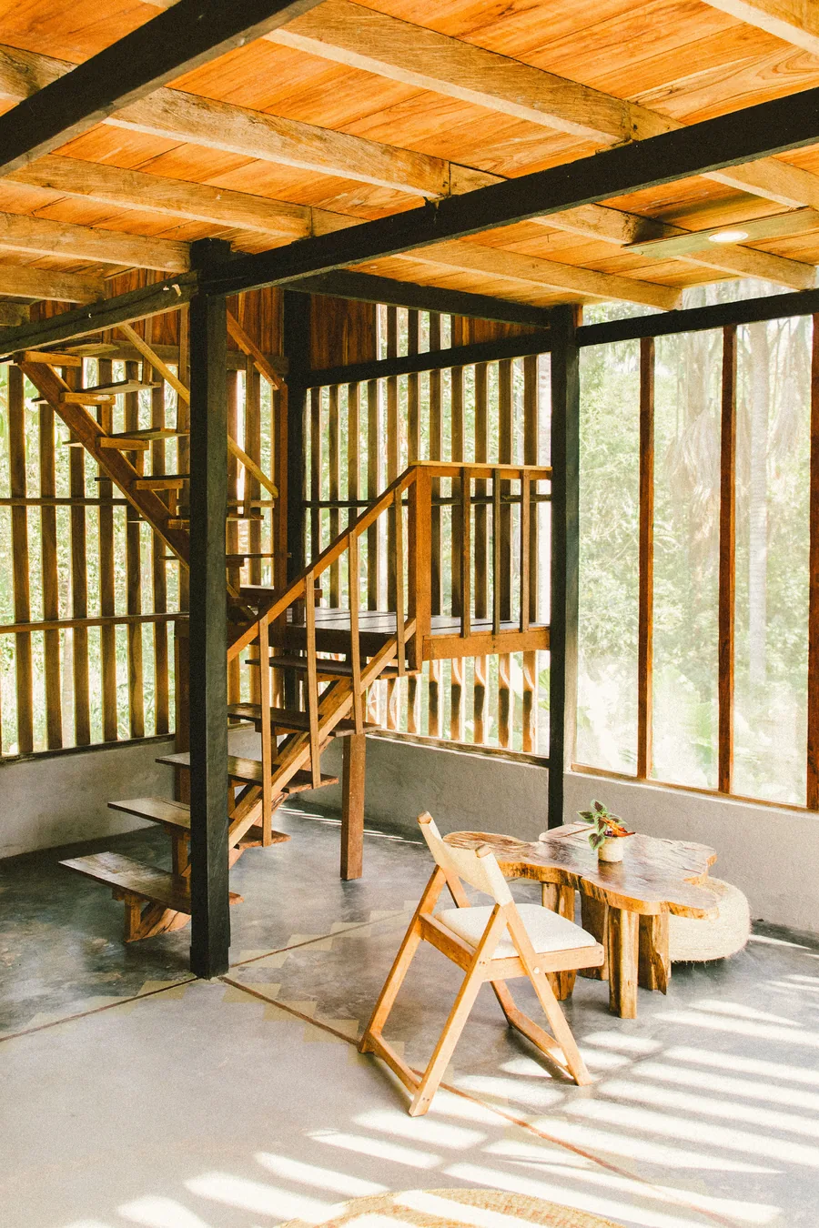 Escalera de madera y zona de estar dentro de la cabaña